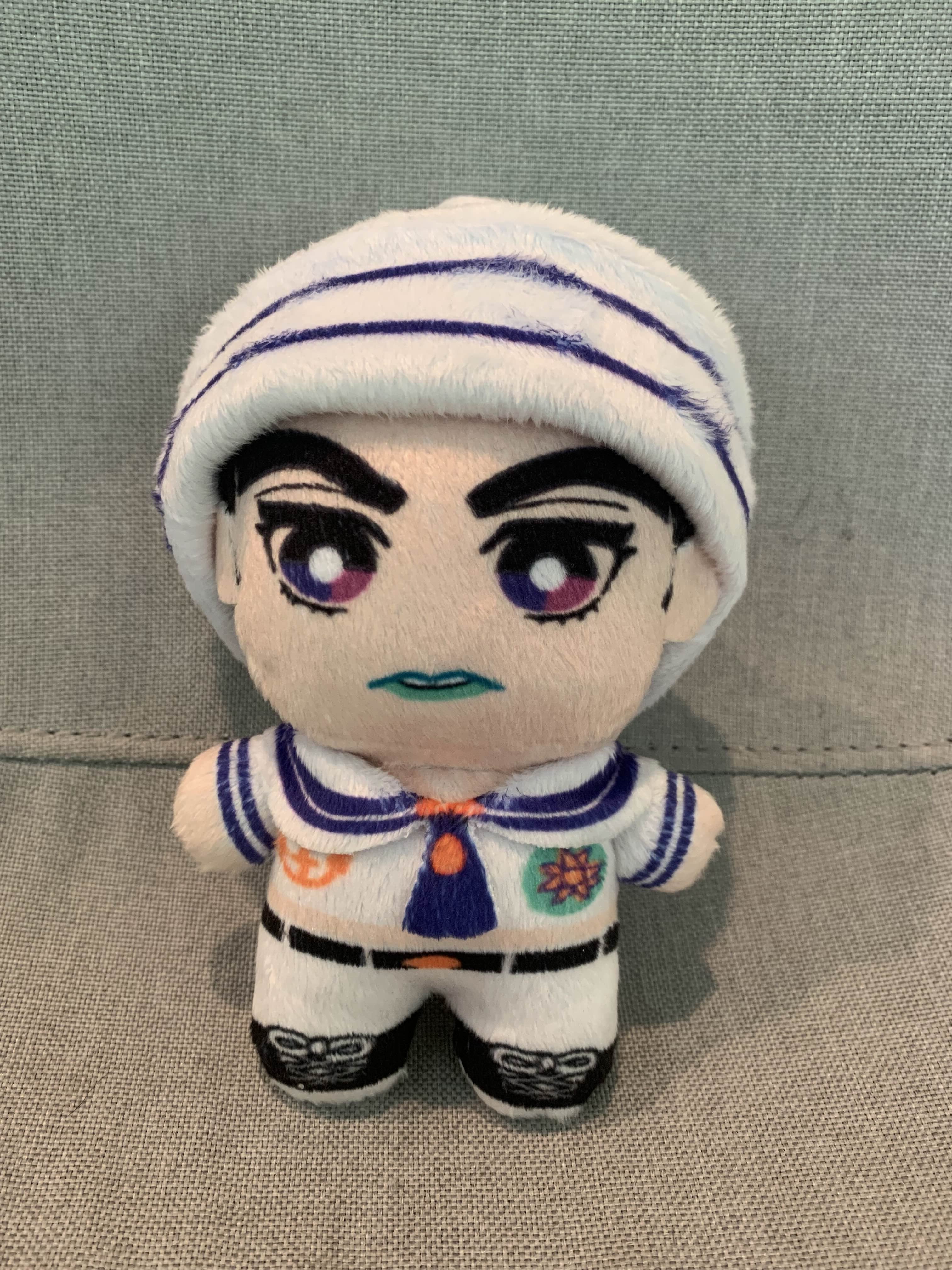 Plush toy in a sailor outfit on a grey background