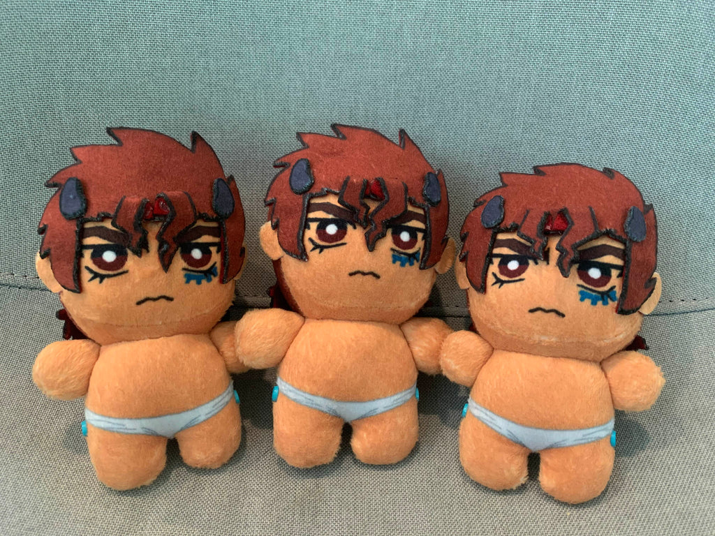 Three plush toys with red hair and angry frowns on a grey background